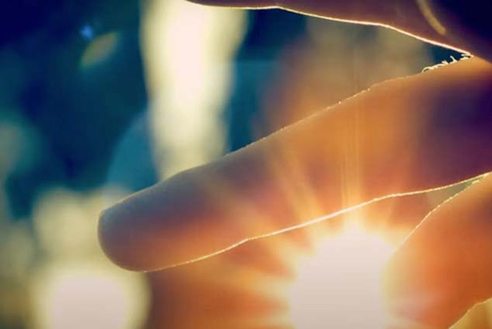 Sunlight peering through human fingers — illustration of phototherapy